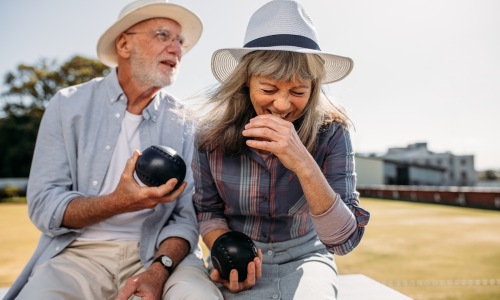 a couple outdoors with pieces of a game in their hands