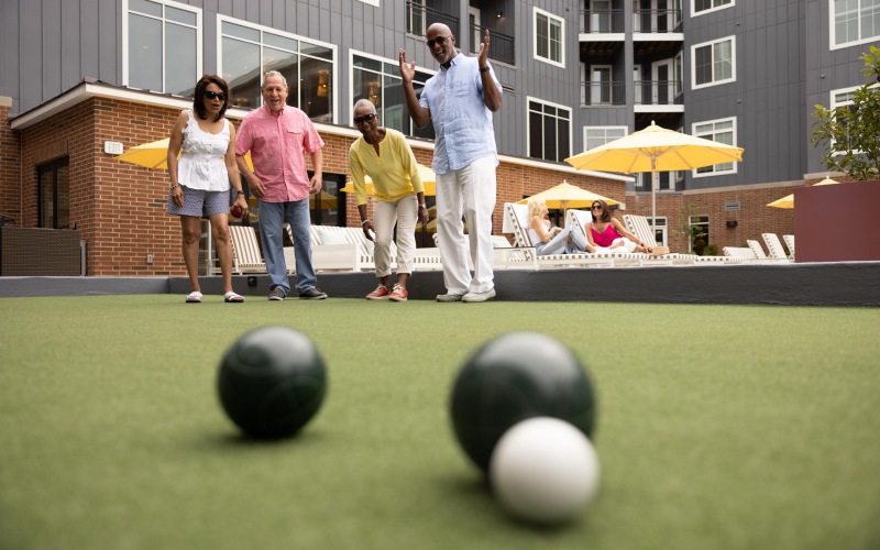 Residente Playing Bocce Ball in the Outdoor Courtyard