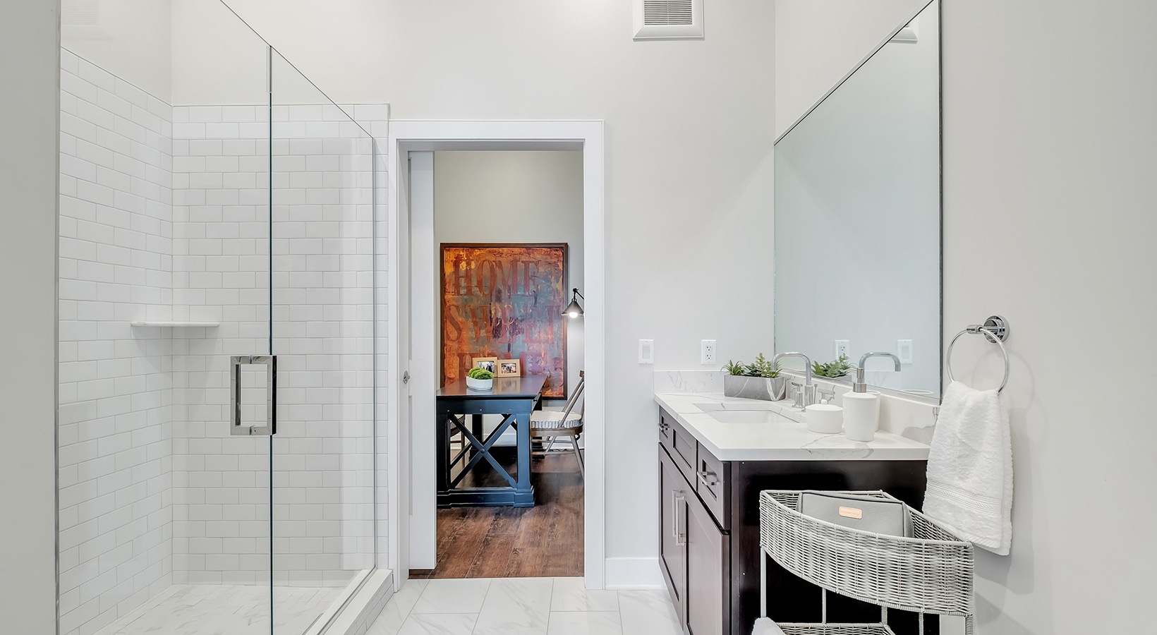 Designer Bathroom Model bathroom at our senior living apartments in Princeton, NJ, featuring white counters and a shower with a glass door.