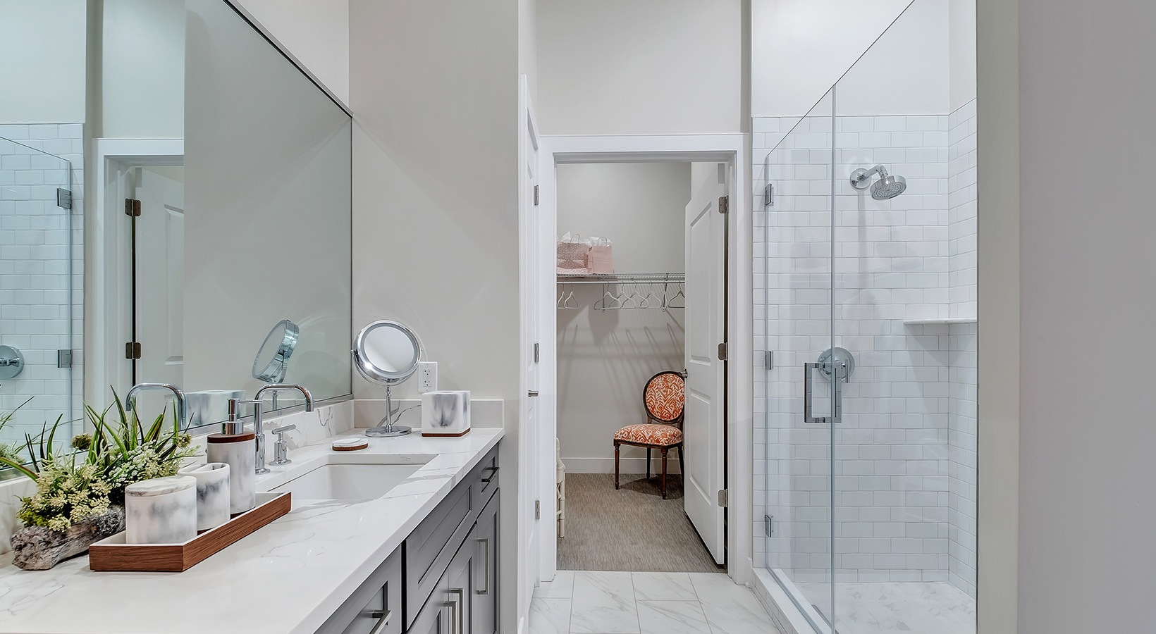 Luxurious Bathroom Model bathroom at our senior living apartments in Princeton, NJ, featuring white counters and a shower with a glass door.