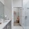 Model bathroom at our senior living apartments in Princeton, NJ, featuring white counters and a shower with a glass door.