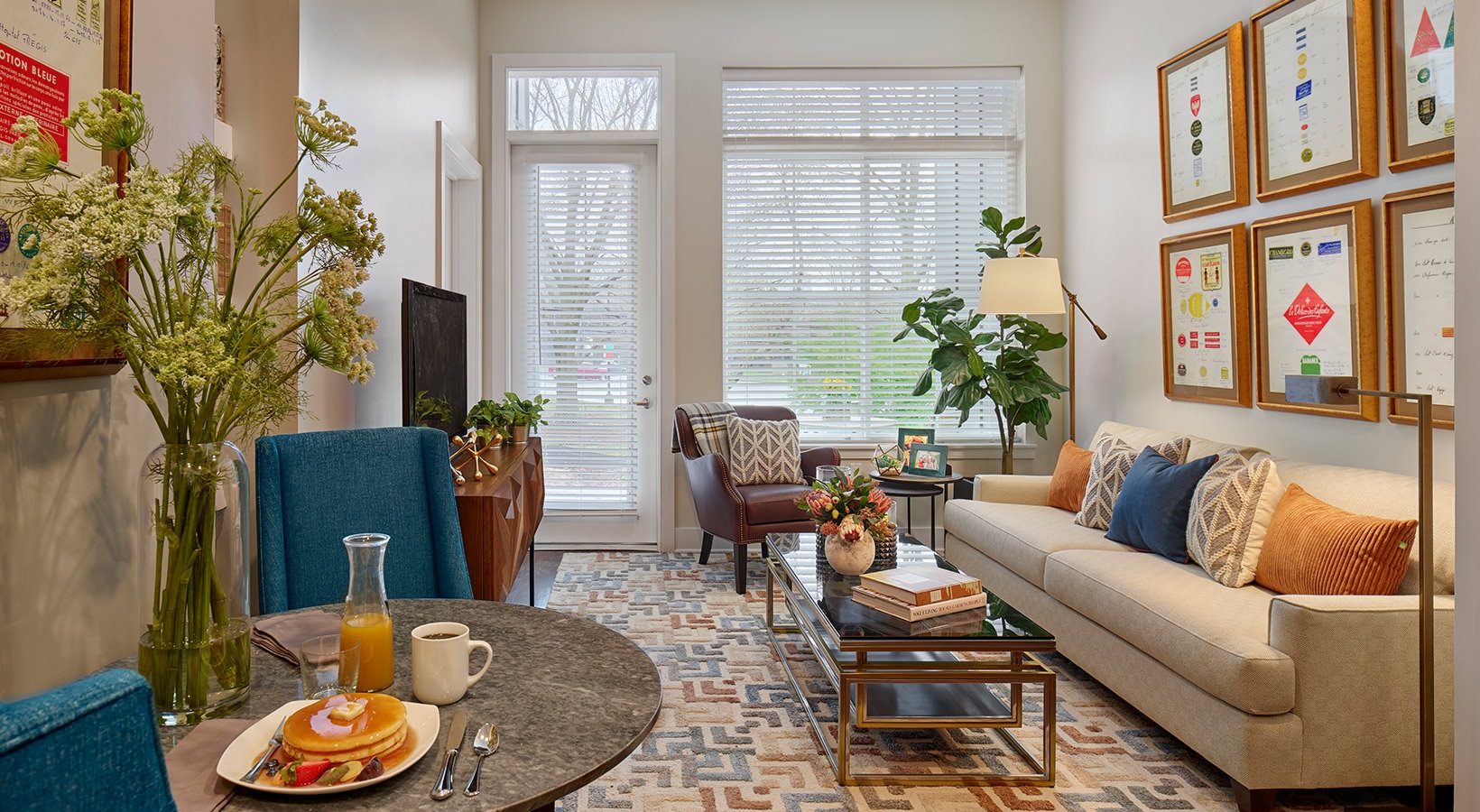Living Room with Breakfast Nook Model living room at our senior living apartments in Plainsboro, NJ, featuring wood grain floor paneling and couches.