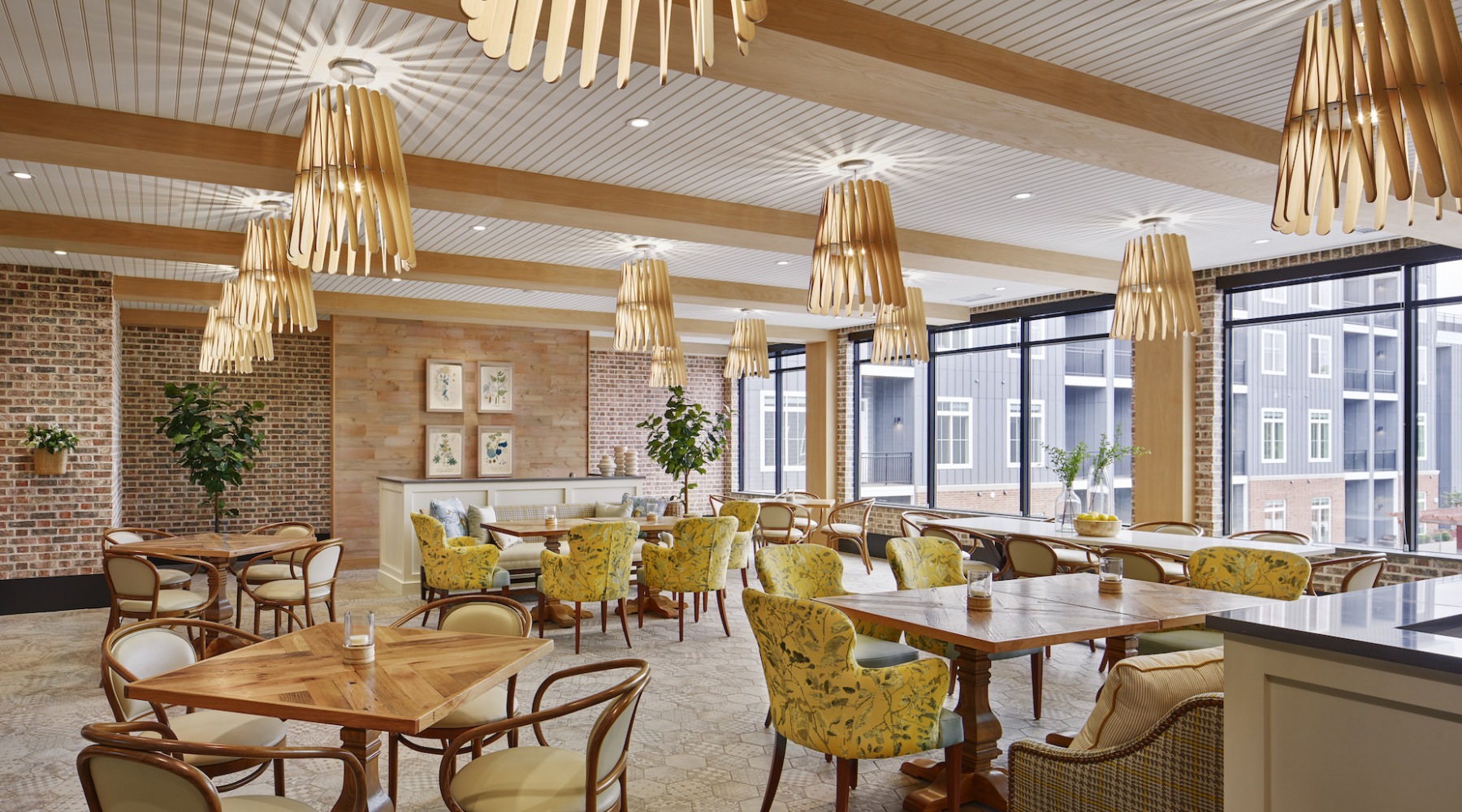 Resident lounge at Icon Riverwalk 55+ apartments in Plainsboro, featuring tables with chairs and wood grain flooring. Resident lounge at Icon Riverwalk 55+ apartments in Plainsboro, featuring tables with chairs and wood grain flooring.