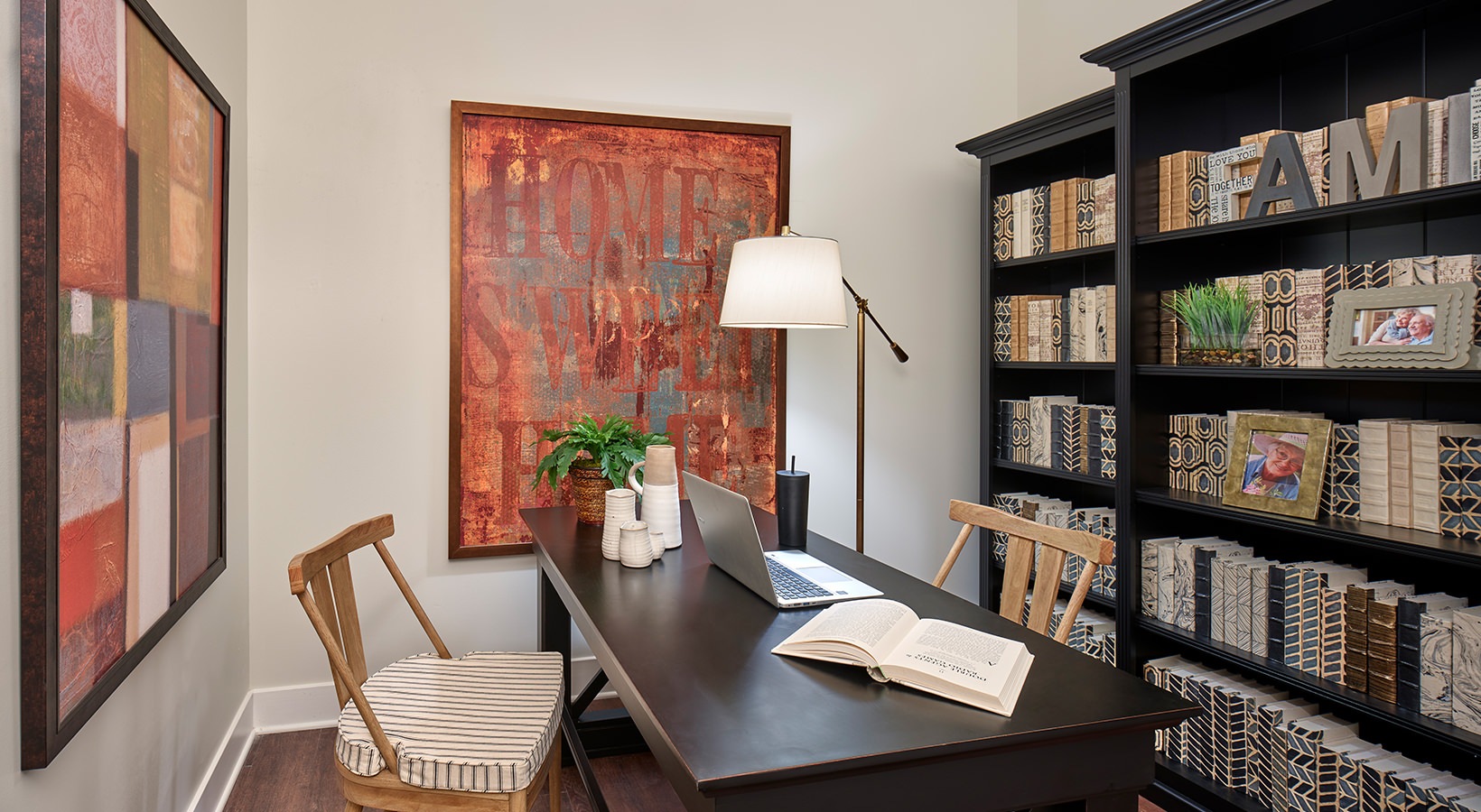 Den Used For Office Space Model office at our senior living apartments in Plainsboro, NJ, featuring a desk with chairs and a bookshelf.