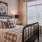 Model bedroom at our senior living apartments in Plainsboro, NJ, featuring wood grain floor paneling and a large bed.