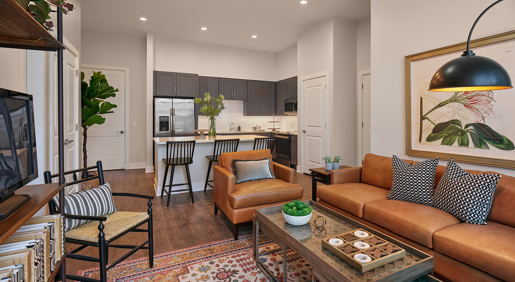 Open Concept Living Room Model living room at our senior living apartments in Plainsboro, NJ, featuring wood grain floor paneling and couches.
