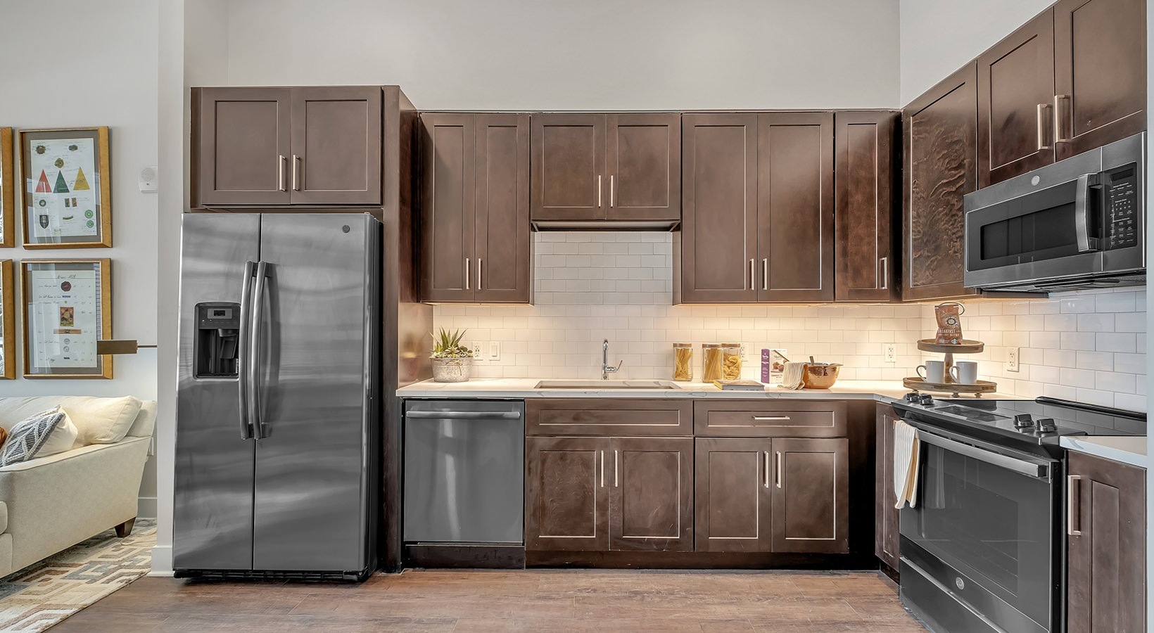 Contemporary Kitchen Model kitchen at our senior living apartments in Plainsboro, featuring a wood grain flooring and stainless steel appliances.