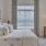 Model bedroom at our senior living apartments in Plainsboro, NJ, featuring windows with blinds and a large bed.