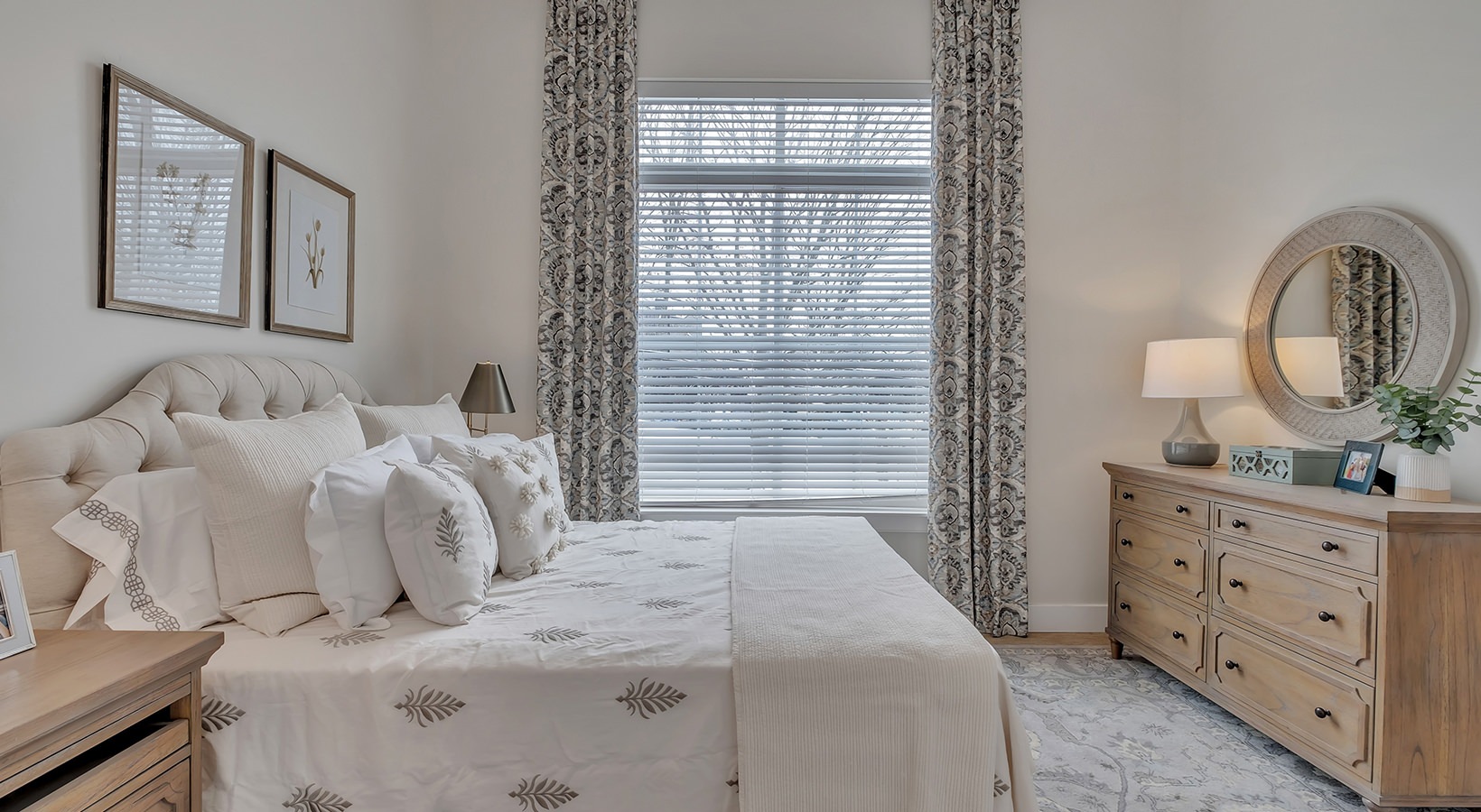 Bedroom with Natural Light Model bedroom at our senior living apartments in Plainsboro, NJ, featuring windows with blinds and a large bed.