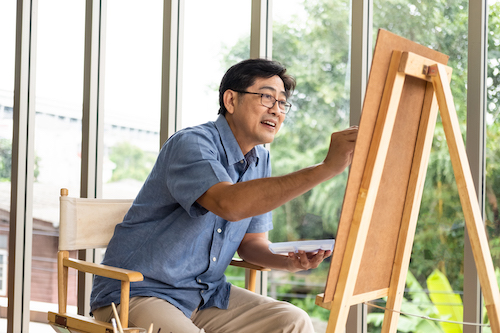 Man sitting on a patio painting